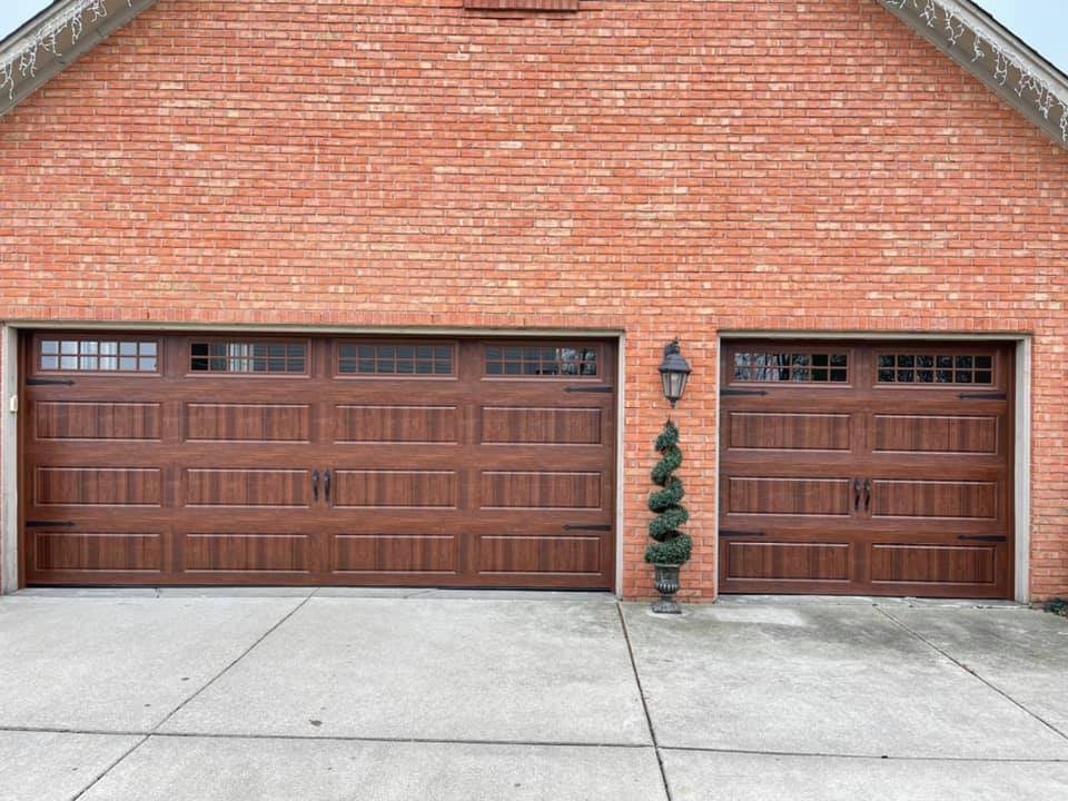 New wood tone garage doors with decorative hardware